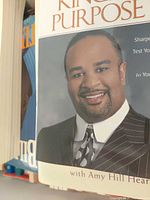 Front cover of motivational paperback showing portrait, edges of adjacent books visible