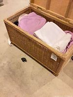 Open wicker trunk showing included linens