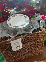 overview showing wicker basket with china and glass plates stacked, wreath visible