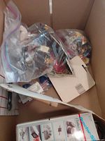 Overview of cardboard box containing Proctor-Silex appliance box and multiple zip bags of small items