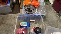 Overview of two storage bins containing assorted plastic food containers and lids