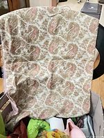 Cream and pink paisley patterned scarf draped over edge of container