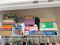 Shelf with stacked sheet protector packs, colored paper reams, mesh basket
