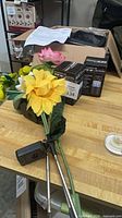Assorted floral solar stake lights, boxed lanterns, paperwork on workbench