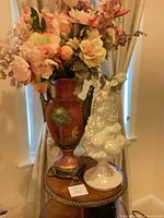 Urn with silk flowers beside white fruit topiary on small table