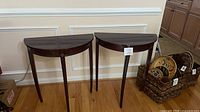 Both demilune tables side by side against wall