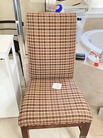 Front view of a plaid fabric dining chair showing upholstery pattern and wooden frame