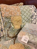 Pillow sham and sealed package on quilt showing pattern and included items