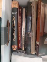 Group of books inside box showing spines and titles