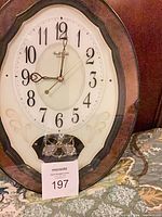 Front view of Rhythm Small World wall clock showing full frame, dial, pendulum
