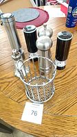 All six items grouped on table: three electric grinders, manual mill, salt shaker, utensil holder