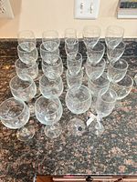 All 24 clear glass stemware pieces displayed on countertop