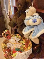 Brown teddy bear, cream teddy bear in blue coat, partial view of doll not part of lot