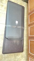 Three stacked dark gray mats showing textures and sizes