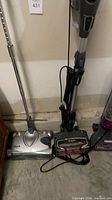 Shark DuoClean stick vacuum beside Shark silver floor sweeper