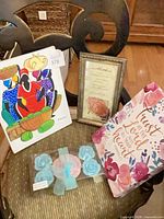 All items together on chair: signed painting, framed poem print, scripture canvas, packaged rose candles/soaps