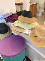 Assorted hats stacked on ledge, showing variety of colours and styles