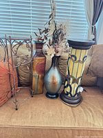 Lot overview showing column lamp, metal vase with flowers, plant stand, square vase