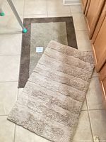 Both bath rugs side by side on tile floor