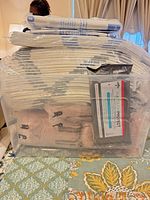 Stacked clear bin containing multiple packs of underpads and protective underwear