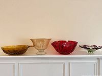 All four decorative glass bowls lined up showing size and color variety