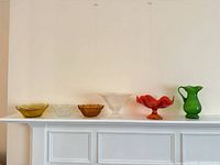 All six glass pieces lined on mantle showing sizes, shapes and colors