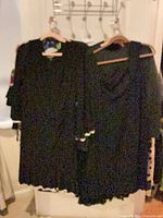Three black garments on hangers, overall lot view