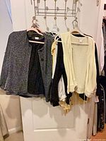Group of assorted jackets and cardigans on door hooks