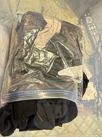 Zip-top bag containing folded black and beige socks