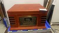 Front view of wood stereo console showing control panel and speaker grilles