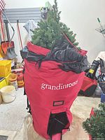 Grandin Road red storage bag open to show artificial tree and metal stand