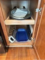 Cabinet view showing pie dish, box grater, silicone bundt pan, blue glass dish
