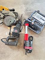 All items grouped: circular saw with blade, reciprocating saw, hanging work light, Dremel kit case
