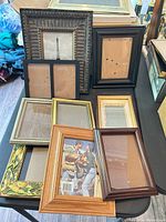 Group of assorted wood picture frames displayed on table