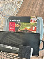 Chefmate marinade tray box with tray beneath, cast iron griddle edge visible