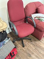 Front view of red fabric swivel desk chair showing seat, backrest, armrests and five-star base