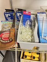 Shelf with hand saw, Hang Up boxes, rope, levels, abrasive roll visible