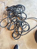 Coiled heavy black extension cord on floor