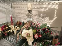 Overall lot on wire shelf showing centerpiece, two glass hurricanes, reindeer candle holder with pillar candle