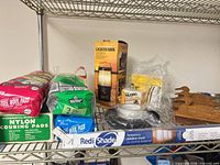 All items on wire shelf: lantern box, steel wool bags, scouring pads box, window shade box, key holder, Velcro pack