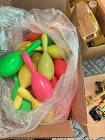 Bag of multicolor plastic maraca shakers inside box