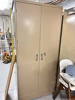 Tan metal cabinet exterior showing double doors and handles