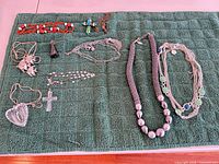 Overview of all nine necklaces and pendants on green towel