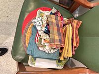 Stack of assorted napkins and placemats on chair