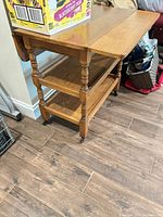 Whole tea cart angled view showing drop leaves down, two shelves and casters