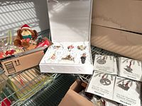 Overview of lot showing plush monkey ornament, porcelain wedding ornament box open, stack of Plow & Hearth pewter ornament packages