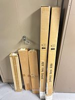 Five sealed Pottery Barn Kids boxes leaning against cabinet