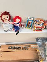 Overall view showing all dolls, boxed items, glass, basket and shipping box
