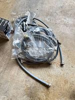 Group of grey hoses in plastic with fittings visible