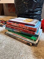 Stack of cookbooks showing titles What’s Cooking in New England?, The Summer Table, Treat Petite, Best of the Best and two unidentified volumes